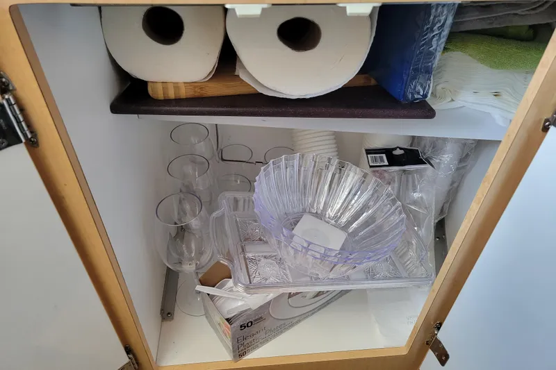 Slide: The Image of Cabinet with paper towels, plastic cups, and bowls on a Bayliner 2655 Ciera boat. - 12