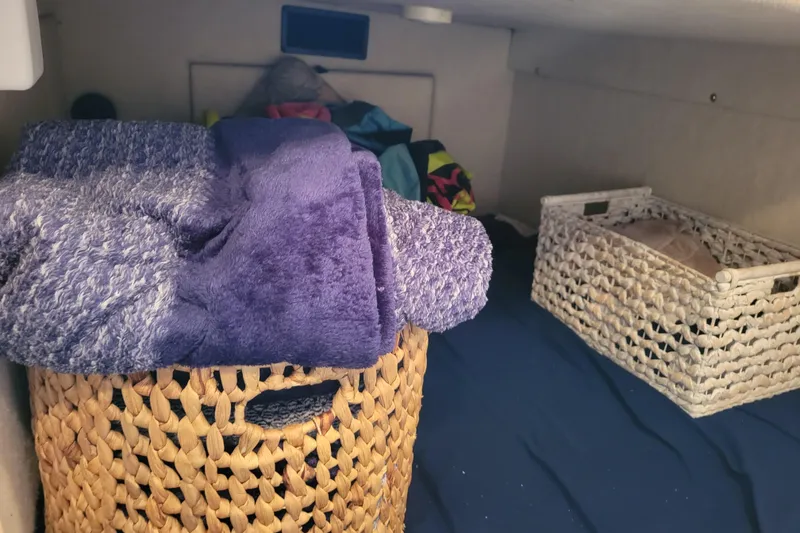 Slide: The Image of Storage area inside a 2001 Bayliner 2655 Ciera with woven baskets and towels. - 18