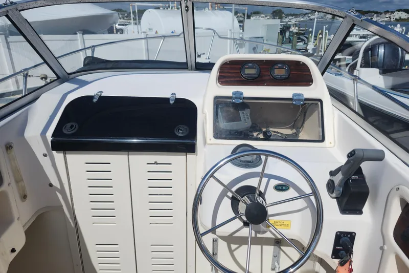 Slide: The Image of 2000 Grady-White Adventure 208 boat helm with steering wheel and control panel. - 5
