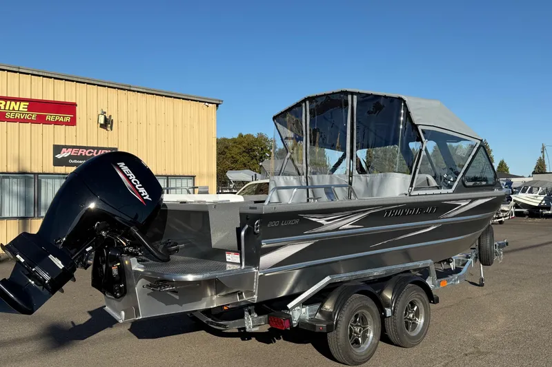 Slide: The Image of 2026 Thunder Jet 200 Luxor boat with Mercury outboard motor, parked outside a marine service shop. - 2