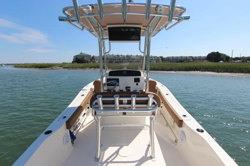 Slide: The Image of 2022 Pioneer 220 Bay Sport boat on calm water near shoreline. - 20