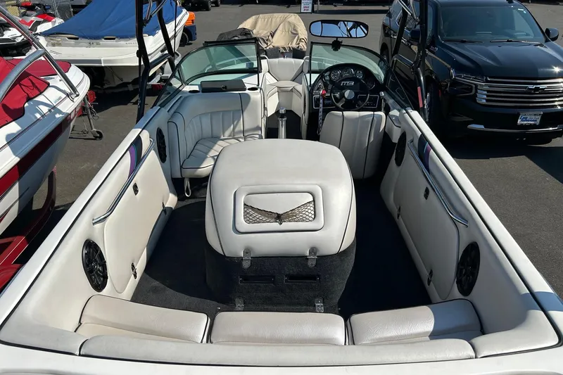 Slide: The Image of 1998 MB Boss 210 boat interior with white seating and dashboard view. - 12