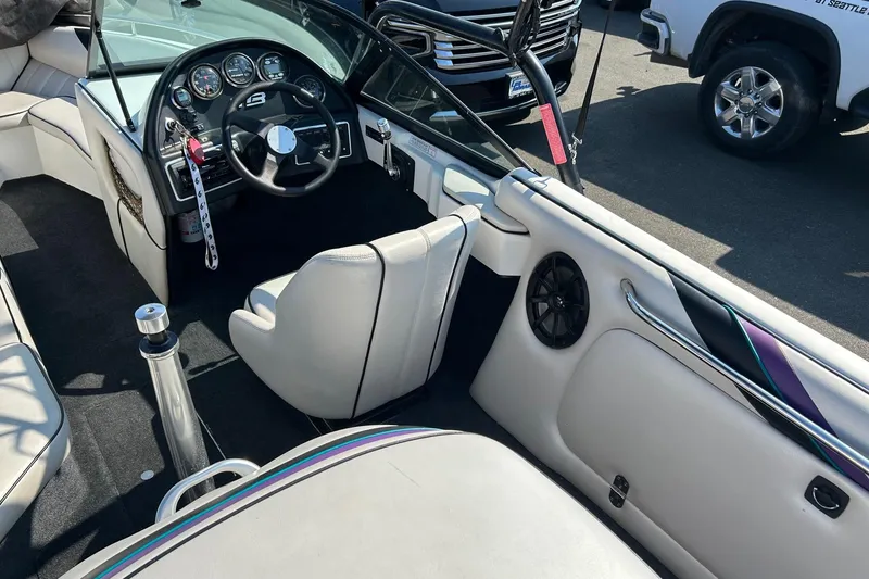 Slide: The Image of Interior of a 1998 MB Boss 210 boat, featuring steering wheel and seating. - 6