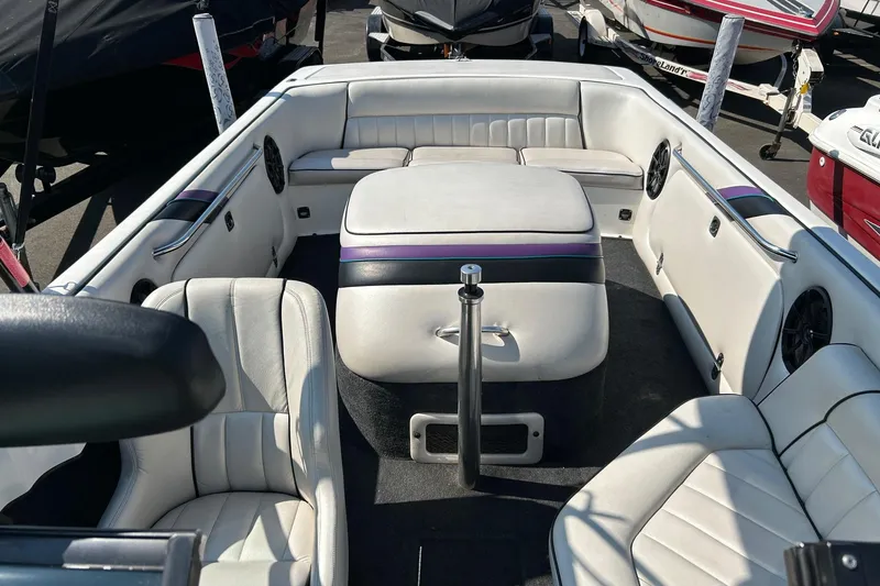 Slide: The Image of Interior of a 1998 MB Boss 210 boat with white seating and purple accents. - 8