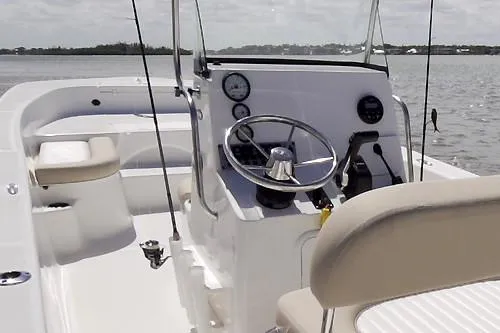 Slide: The Image of 2026 Sundance DX22 boat interior with center console and seating in a workshop setting. - 10