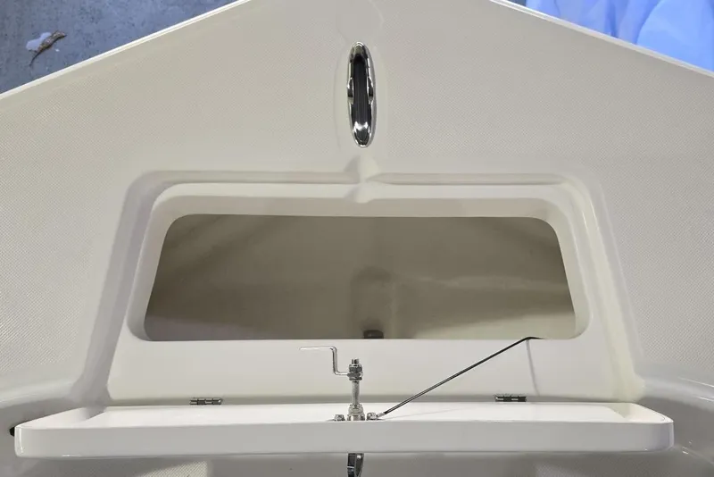 Slide: The Image of 2026 Sundance DX22 boat compartment with open hatch and latch mechanism. - 16