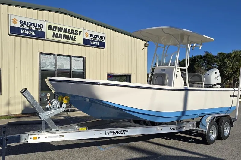 Slide: The Image of 2026 Sundance DX22 boat on trailer at Downeast Marine dealership. - 17