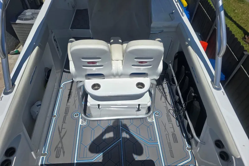 Slide: The Image of 2016 Extreme Boats 38 Cuddy Cabin interior with seating and canopy, parked outdoors. - 10