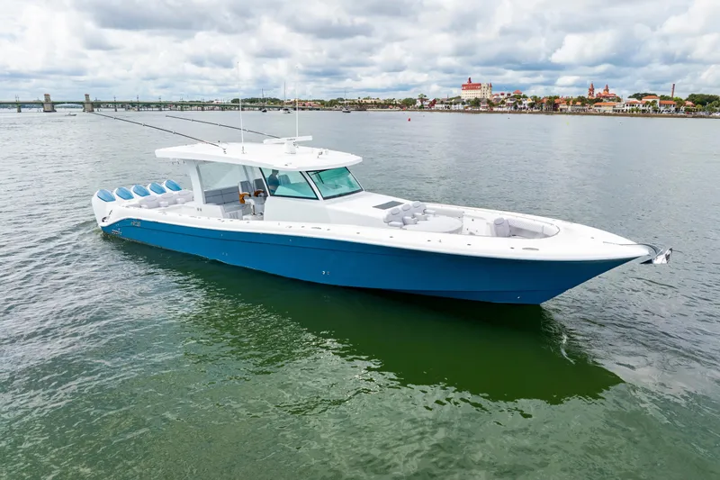 Slide: The Image of 2026 HCB 56 Suenos GIX luxury boat on calm water, blue and white design. - 4