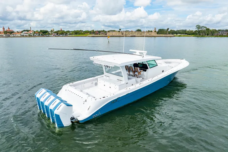 Slide: The Image of 2026 HCB 56 Suenos GIX boat on calm water, featuring multiple outboard engines. - 6