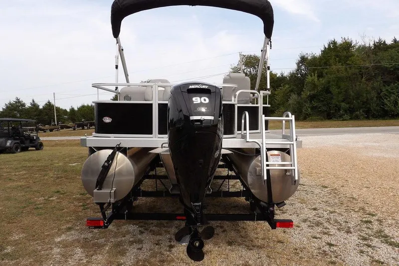 Slide: The Image of 2023 Bennington 20 SVF pontoon boat with Mercury 90 engine, parked on gravel. - 4