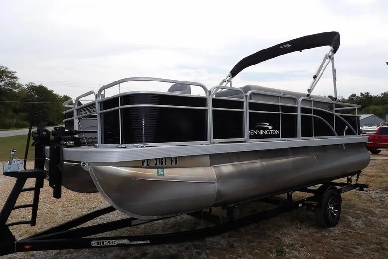 Slide: The Image of 2023 Bennington 20 SVF pontoon boat on trailer, parked outdoors. - 8