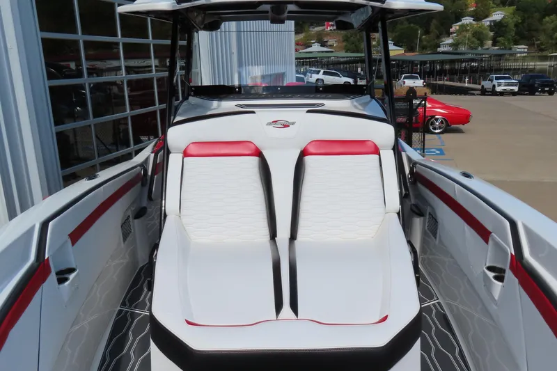 Slide: The Image of 2022 Sunsation 32CCX boat interior with red and white seating, docked outdoors. - 13
