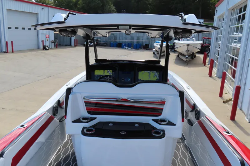 Slide: The Image of 2022 Sunsation 32CCX boat interior with modern dashboard and seating, docked at a marina. - 7