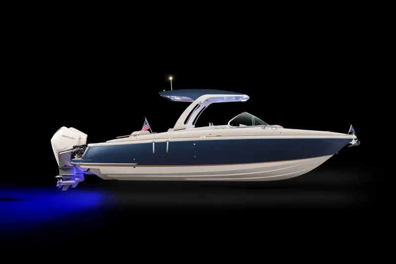 The Image of 2026 Chris-Craft Launch 31 GT boat with sleek design and blue hull, illuminated in dark setting. - 0