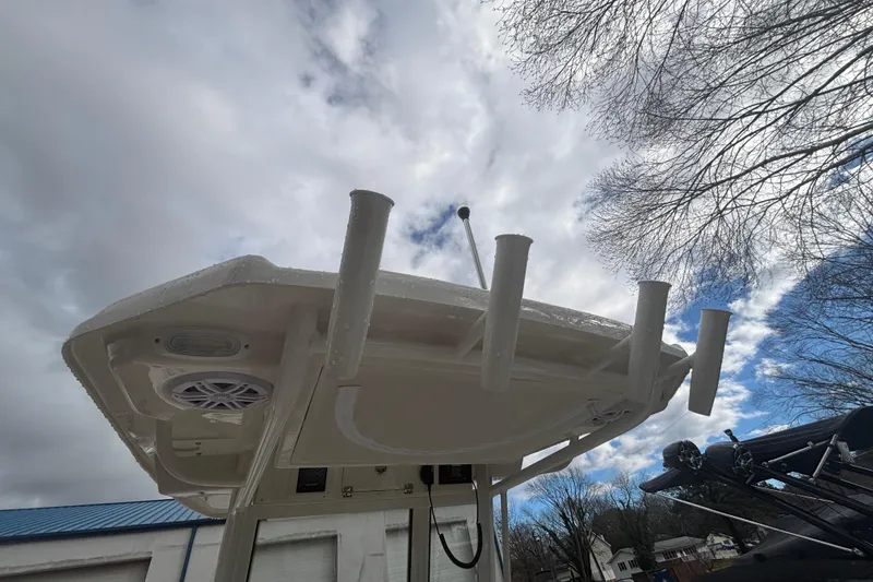 Slide: The Image of 2026 Sailfish 252 CC boat with rod holders and speaker, under cloudy sky. - 12
