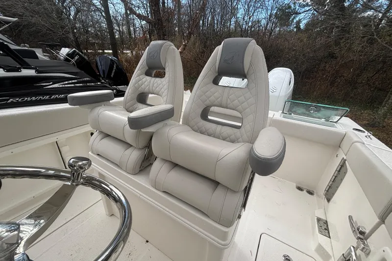 Slide: The Image of 2026 Sailfish 252 CC boat with luxurious dual captain's chairs and sleek steering wheel. - 24