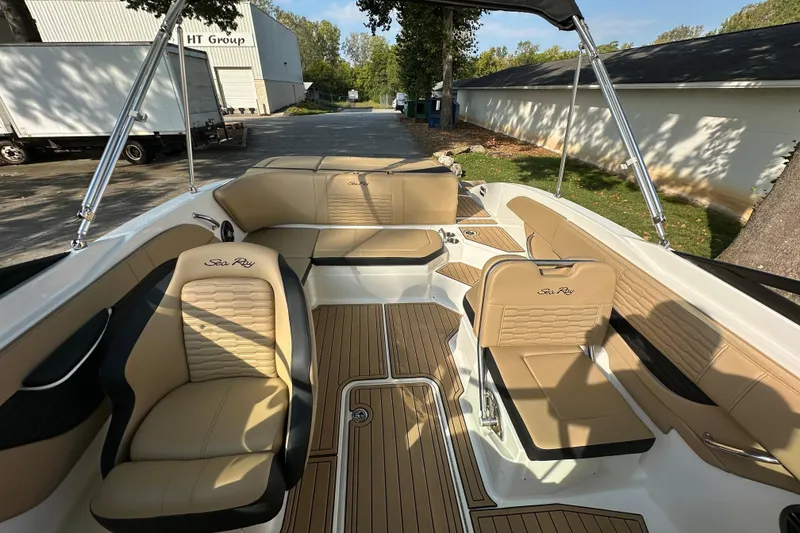 Slide: The Image of 2024 Sea Ray SPX 210 boat interior with tan seating and wood-style flooring. - 11