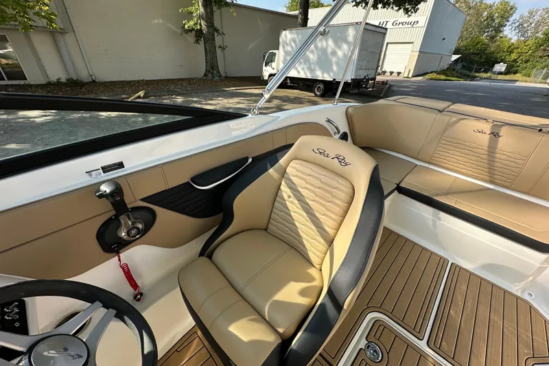 Slide: The Image of 2024 Sea Ray SPX 210 boat interior with tan seating and steering wheel. - 12