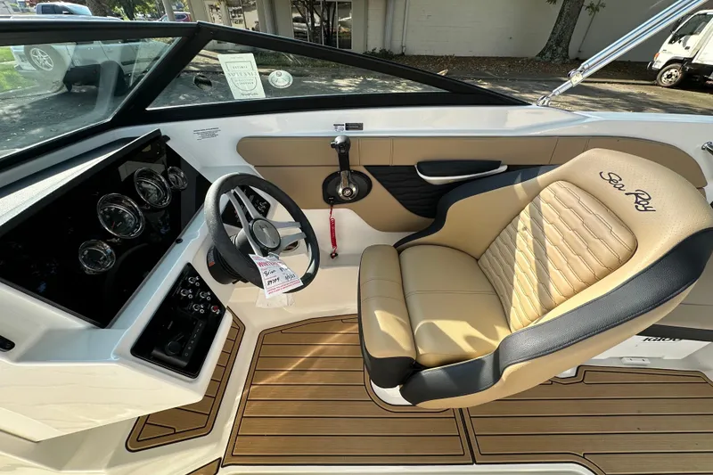Slide: The Image of 2024 Sea Ray SPX 210 boat interior with tan seating and modern dashboard controls. - 13