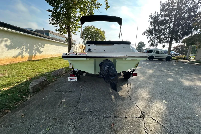 Slide: The Image of 2024 Sea Ray SPX 210 boat parked on a driveway, rear view. - 2