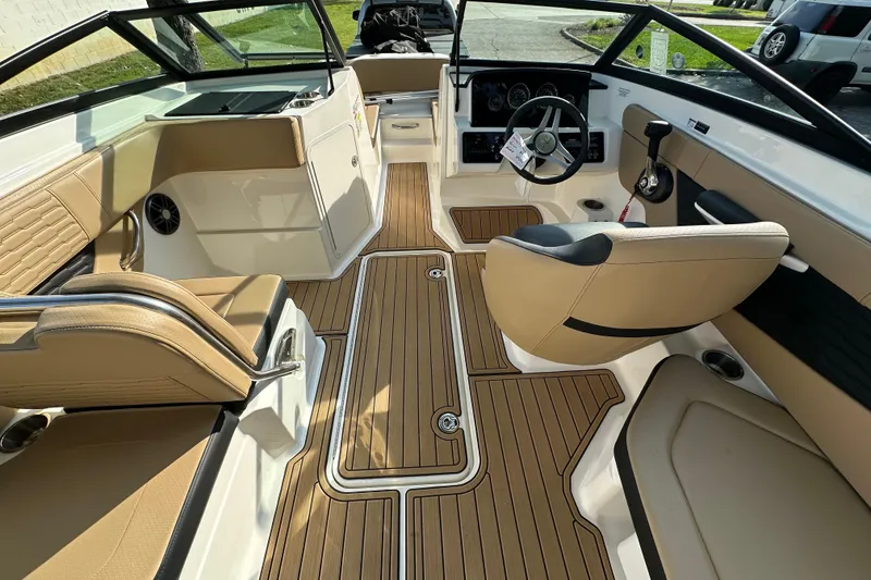 Slide: The Image of 2024 Sea Ray SPX 210 boat interior with tan seating and wood-style flooring. - 7