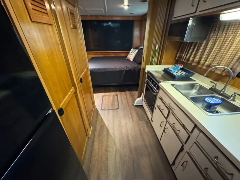 Slide: The Image of Interior of a 1994 Gibson 44 boat with kitchen and bedroom area. - 49