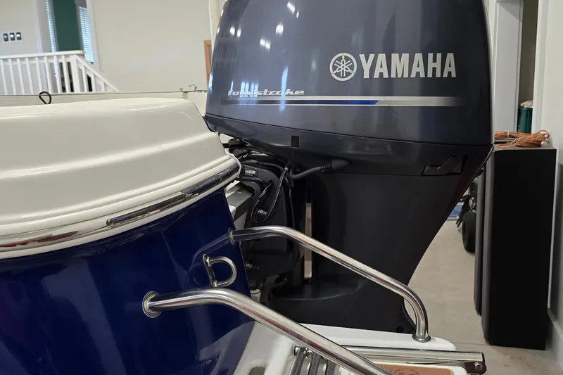 Slide: The Image of 2019 NauticStar 231 Hybrid boat with Yamaha outboard motor in a garage. - 16