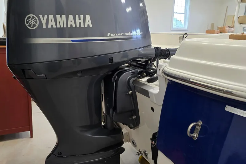 Slide: The Image of 2019 NauticStar 231 Hybrid with Yamaha four-stroke outboard engine in a garage setting. - 17