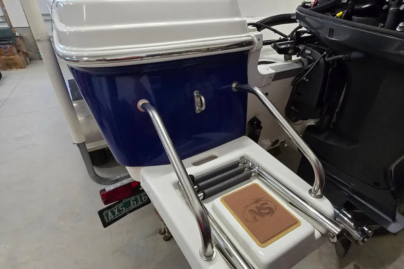 Slide: The Image of 2019 NauticStar 231 Hybrid boat with stainless steel swim ladder and blue hull. - 18