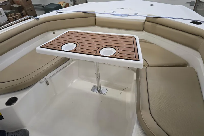 Slide: The Image of 2019 NauticStar 231 Hybrid boat interior with cushioned seating and a wooden table. - 21