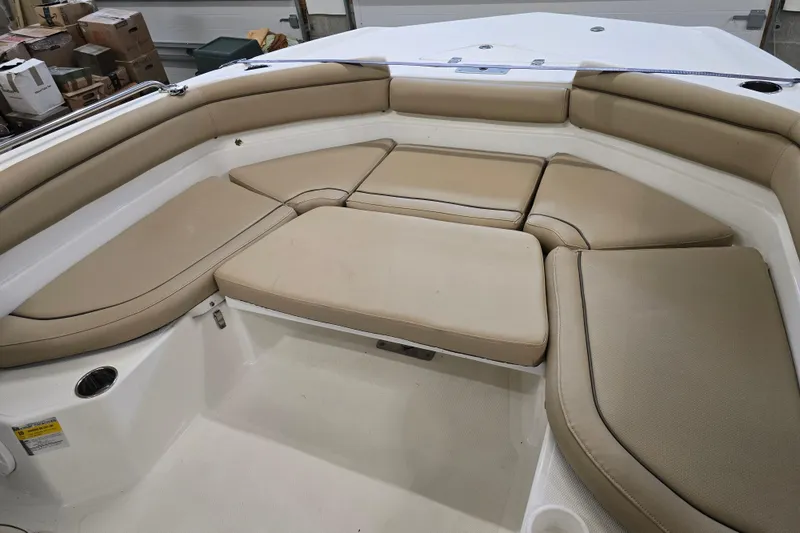 Slide: The Image of 2019 NauticStar 231 Hybrid boat interior with beige cushioned seating. - 22