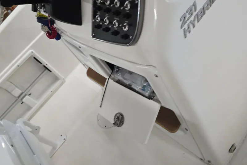 Slide: The Image of 2019 NauticStar 231 Hybrid boat console with open storage compartment and control panel. - 34