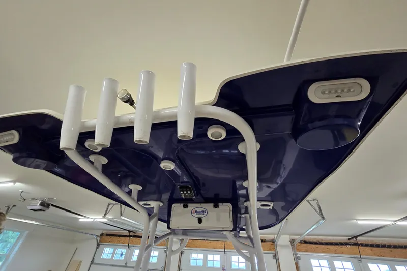 Slide: The Image of 2019 NauticStar 231 Hybrid boat T-top with rod holders in a garage setting. - 35