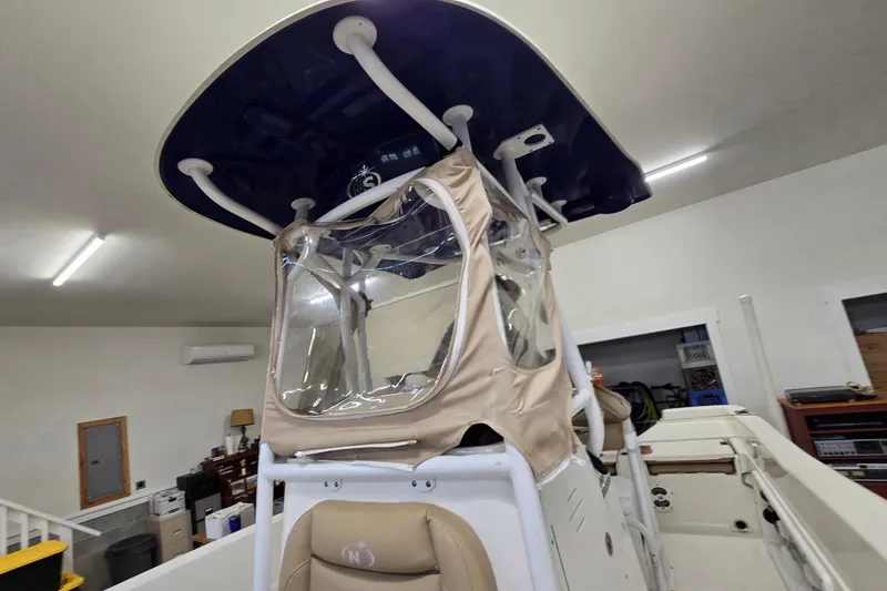 Slide: The Image of 2019 NauticStar 231 Hybrid boat interior with protective cover in a garage setting. - 36