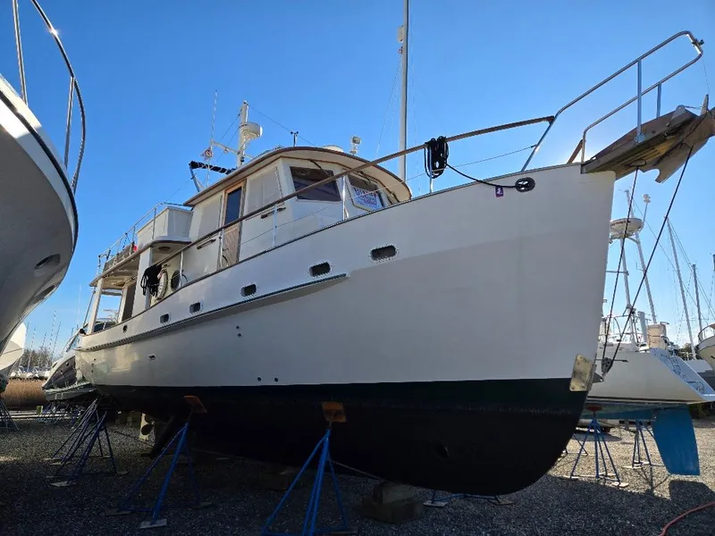 Slide: The Image of 1985 Kadey-Krogen 42 yacht on stands, side view, clear sky background. - 3