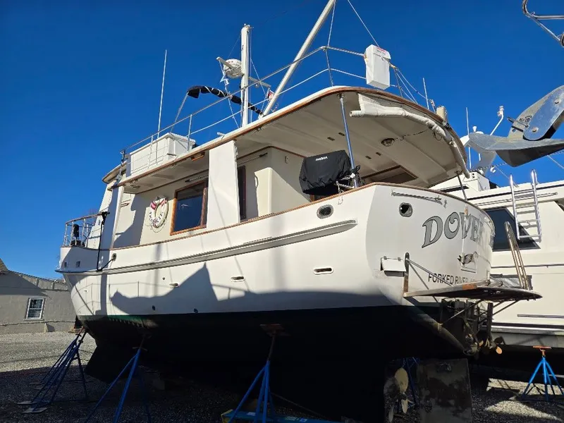 Slide: The Image of 1985 Kadey-Krogen 42 yacht on stands, white hull, clear blue sky background. - 5
