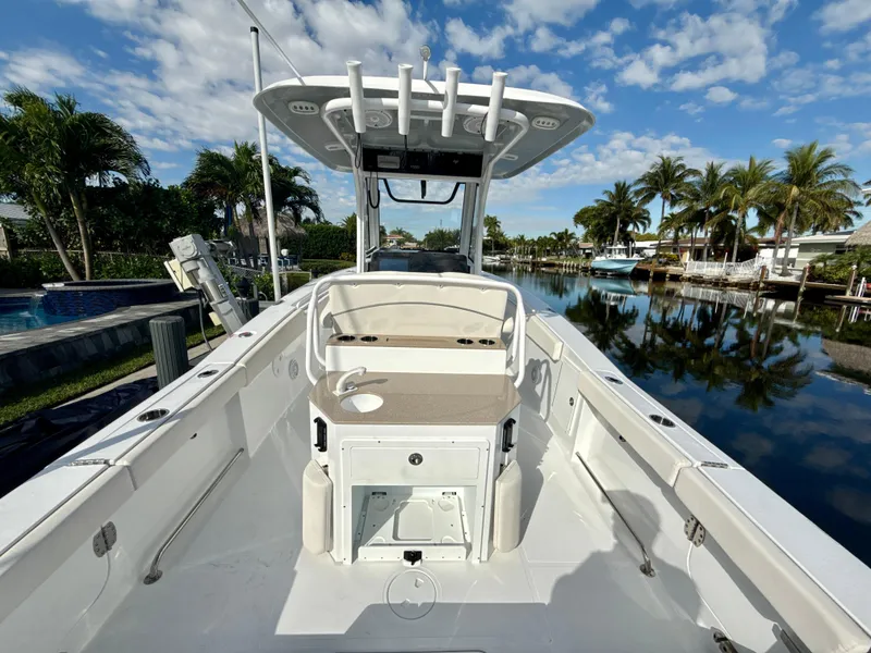 Slide: The Image of 2024 Sea Hunt Ultra 275 SE boat docked by a scenic canal with palm trees. - 10
