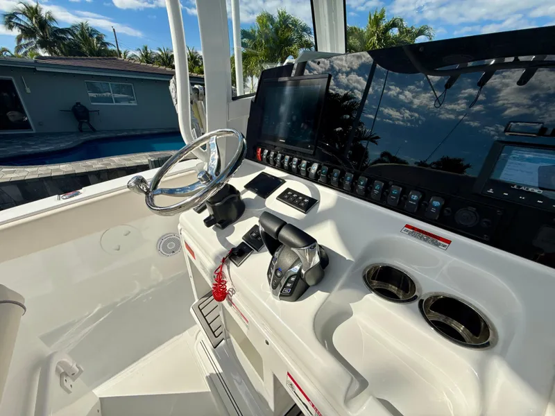 Slide: The Image of 2024 Sea Hunt Ultra 275 SE boat dashboard with steering wheel and controls. - 13