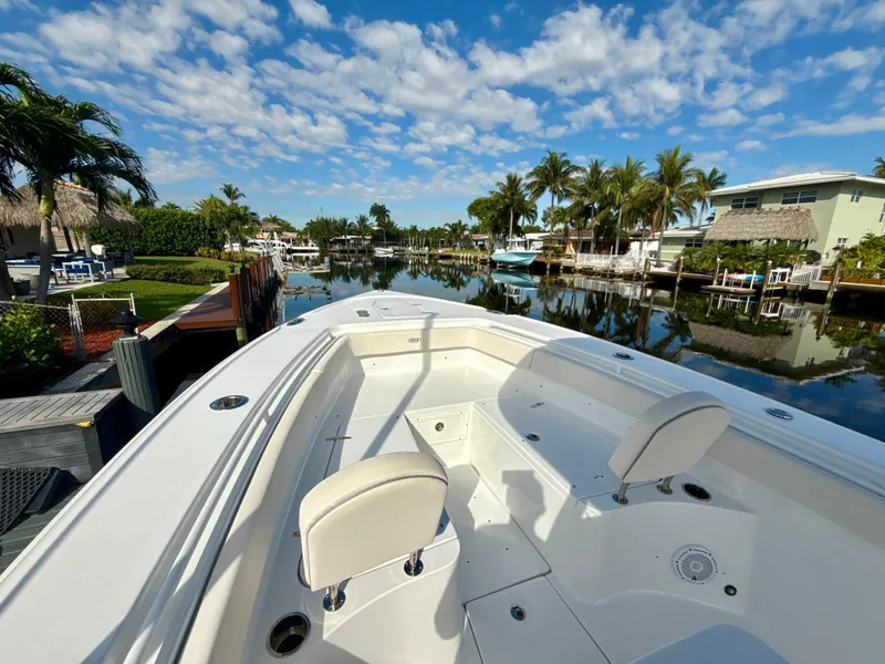 Slide: The Image of 2024 Sea Hunt Ultra 275 SE boat docked in a scenic canal with palm trees. - 18