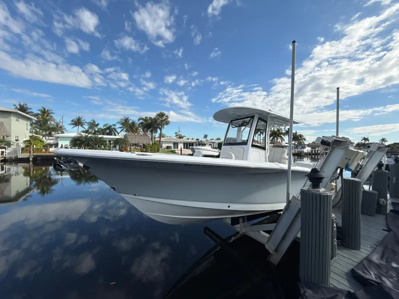 Slide: The Image of 2024 Sea Hunt Ultra 275 SE boat docked on a sunny day with palm trees. - 29