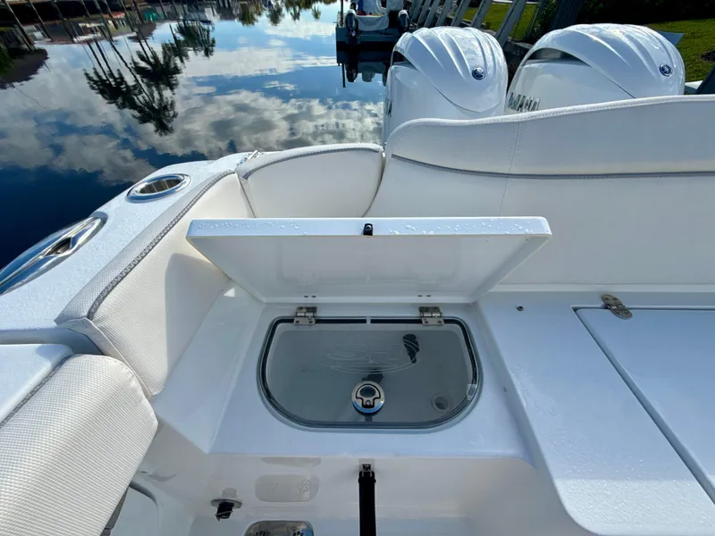 Slide: The Image of 2024 Sea Hunt Ultra 275 SE boat interior with open storage compartment and twin engines. - 7