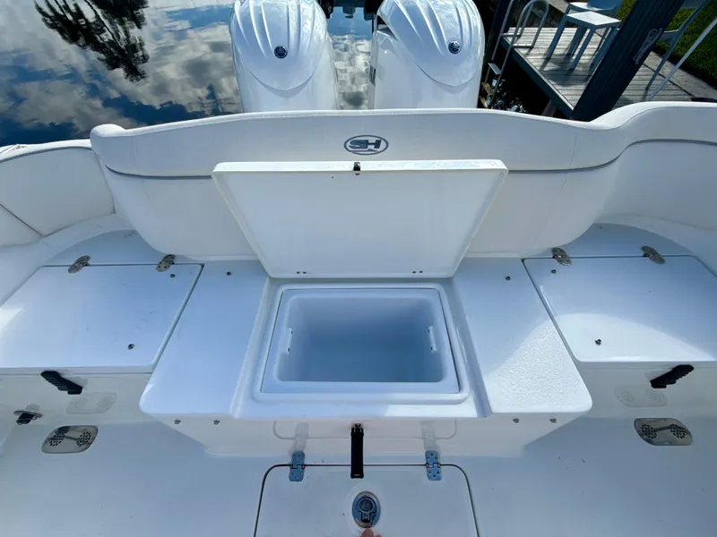 Slide: The Image of 2024 Sea Hunt Ultra 275 SE boat with open storage compartment and twin engines. - 8