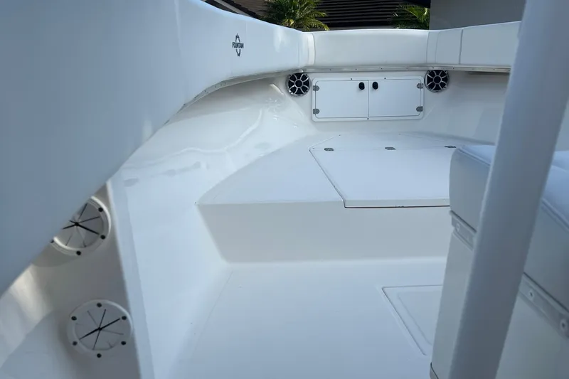 Slide: The Image of 2002 Fountain 29 Center Console boat interior with white seating and storage compartments. - 10