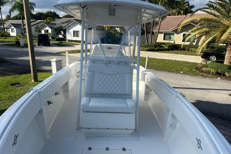 Slide: The Image of 2002 Fountain 29 Center Console boat with white seating, parked in a residential area. - 6
