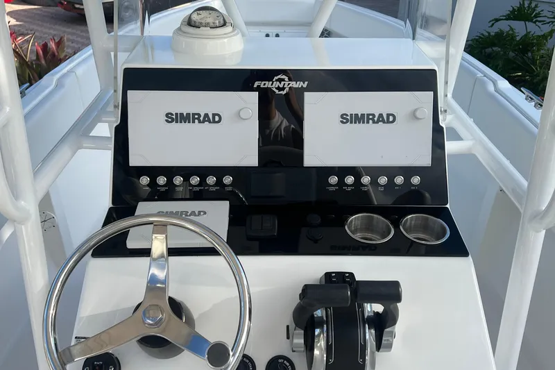 Slide: The Image of Center console of 2002 Fountain 29 with Simrad navigation system and steering wheel. - 9