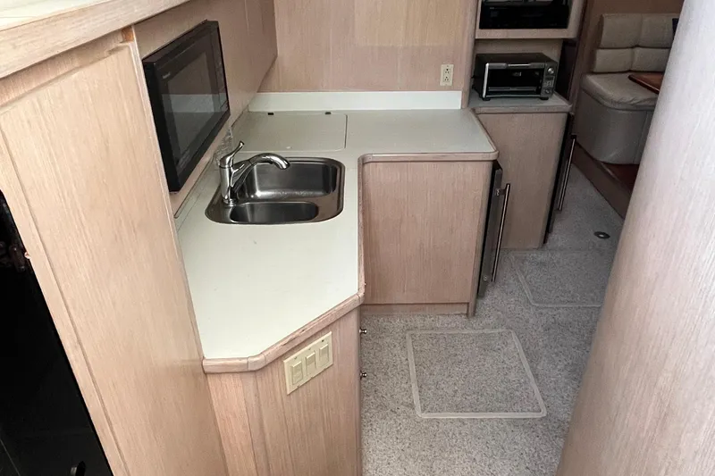 Slide: The Image of 1994 Tiara Yachts 4000 Express interior kitchen with sink, microwave, and cabinetry. - 15