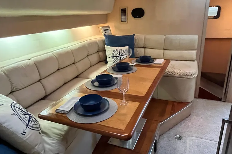 Slide: The Image of 1994 Tiara Yachts 4000 Express interior with dining area, cushioned seating, and elegant table setting. - 18