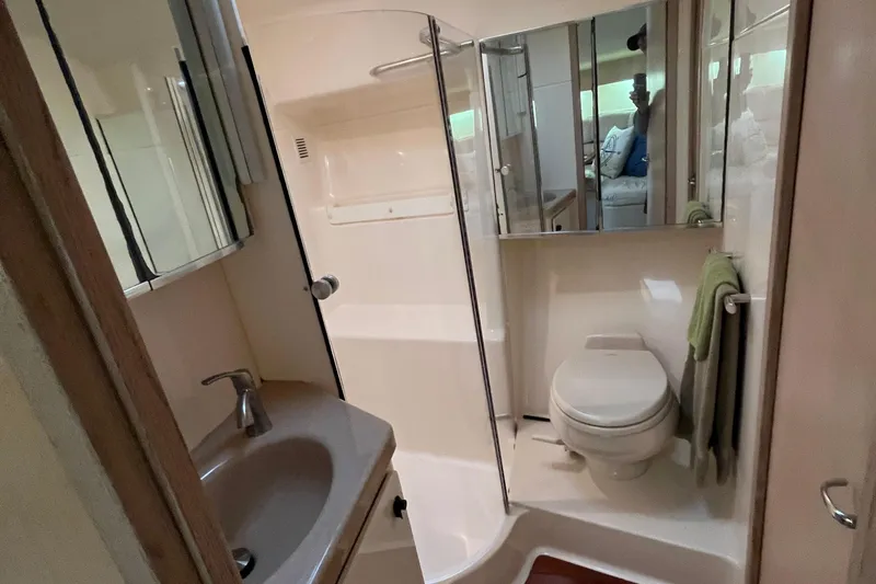 Slide: The Image of Bathroom interior of a 1994 Tiara Yachts 4000 Express, featuring sink, toilet, and shower. - 22