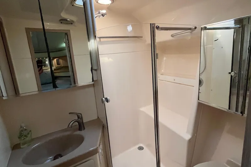 Slide: The Image of 1994 Tiara Yachts 4000 Express bathroom with shower, sink, and mirrored cabinets. - 23